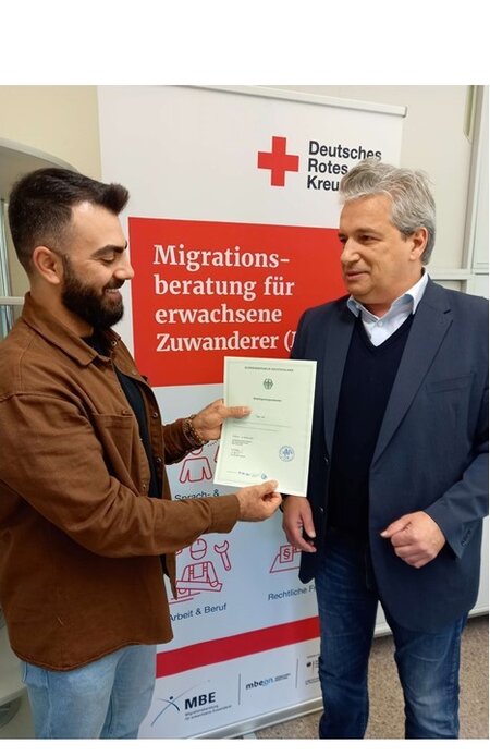 2023: Bild MBE mit Einbuergerungsurkunde